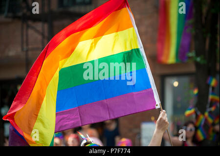 Teilnehmer mit großen, hintergrundbeleuchteten Regenbogen Flagge in die jährliche Gay Pride Parade, wie es durch Greenwich Village. Stockfoto