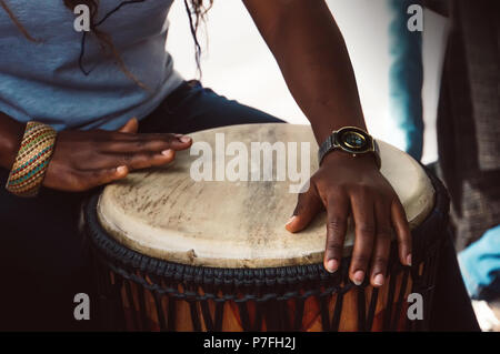 In der Nähe der Hände einer Frau Spielen eines Drum. Nigerianischen Frau spielen eine traditionelle afrikanische Trommel Stockfoto