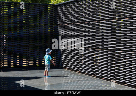 Ein kleiner Junge steht im Inneren Pool der Serpentine Pavillon 2018 entworfen von dem Architekten Frida Escobedo. Stockfoto