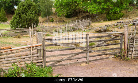 Geschlossen hölzerne Tor in einem traditionellen skandinavischen roundpole Zaun. Lage, Stensjo in Smaland, Schweden. Stockfoto