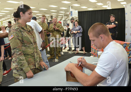 Rob Gronkowski (* 1989) ist ein ehemaliger American Football Tight End, der für die New England Patriots spielte und zwei Super Bowl-Titel gewann. Das Archivbild dokumentiert, dass er einen Fußball für einen Soldaten der US-Armee während einer öffentlichen Veranstaltung an der Lewis Main Exchange am 27. Juni 2018 unterschrieb. Stockfoto