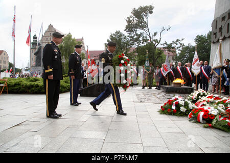 Brigadier General Richard R. Coffman, 1 Infanterie Division Mission Befehl Element Commander, Sgt. Maj. Sael Garcia, 1 Inf. Div. MCE Sergeant Major, Oberstleutnant Gerald Walsh, 415Th zivilen Angelegenheiten Bataillonskommandeur, die 1956 Posener Aufstand gedenken Mit einer Kranzniederlegung im Namen der United States Army während einer Zeremonie zum 28. Juni 2018, am Kreuze Denkmal in Posen, Polen, zu Ehren der polnischen Bürger, die gegen die kommunistische Herrschaft vor 62 Jahren stand. Die massiven Proteste im Jahr 1956 waren die ersten von vielen, in denen Hunderte von polnischen Volk opferte ihr Leben für die Unabhängigkeit der Stockfoto