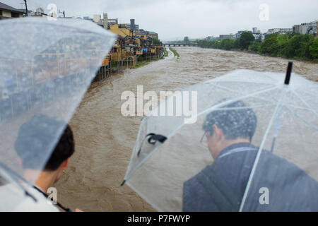 Kyoto, Japan. 6. Juli, 2018. Von Kyoto Main, die kamogawa, die Ufer, senden Wasser über Gehwege in der Regel mit Touristen und Bewohner beschäftigt. Stockfoto