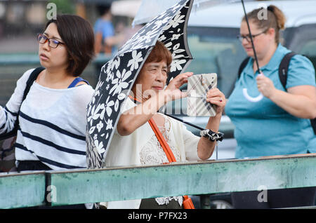 Kyoto, Japan. 6. Juli, 2018. Eine Frau nimmt ein Foto auf der Main von Kyoto, die kamogawa, die seine Ufer platzen. Credit: Trevor Mogg/Alamy leben Nachrichten Stockfoto