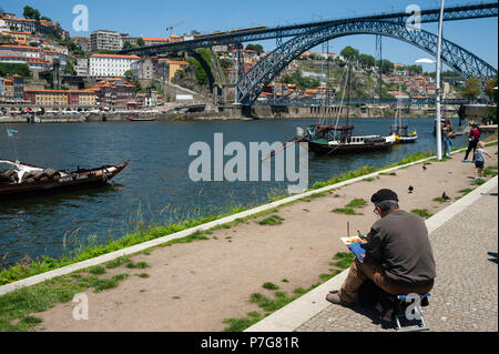 14.06.2018, Porto, Portugal, Europa - ein Mann sitzt am Ufer des Douro und malt ein Bild von Porto das Stadtbild. Stockfoto