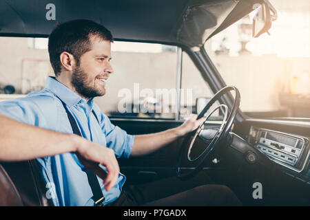 Schöner Mann in seinem alten Oldtimer sitzen Stockfoto