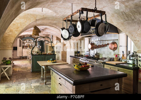 Verschiedene Pfannen hängen an Rack über Küche Insel im 18. Jahrhundert Schlösser, St Remy De Provence Stockfoto