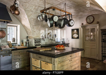 Verschiedene Pfannen hängen an Rack über Küche Insel im 18. Jahrhundert Schlösser, St Remy De Provence Stockfoto