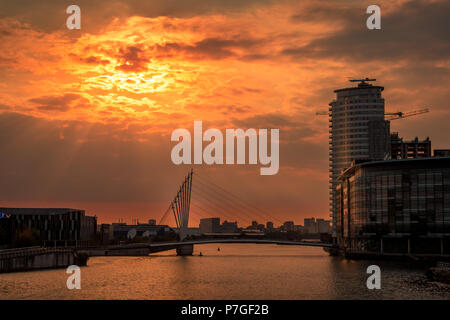 Einen schönen himmlischen Sonnenuntergang über Salford Quays, der Himmel glänzt mit einem orange Glühen von der Sonne in den Wolken umschlossen. Stockfoto