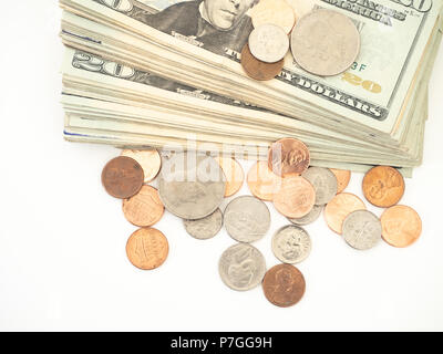 Nahaufnahme von uns zwanzig Dollar, Rechnungen und verstreuten Münzen vor einem weißen Hintergrund. Stockfoto