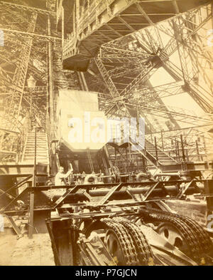 Englisch: Eiffelturm Maschinen mit Mann neben Rad, Aufzug wirft, während der Pariser Weltausstellung. 1889 143 Eiffelturm Maschinen mit Mann neben Rad, Aufzug wirft, während Paris Exposition Stockfoto