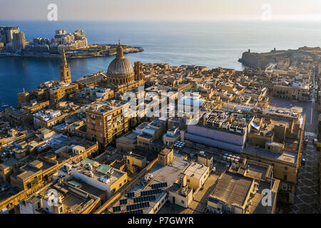 Valletta, Malta - Unsere Liebe Frau vom Berge Karmel Kirche und St. Paul's Cathedral von oben mit Sliema im Hintergrund bei Sonnenaufgang Stockfoto