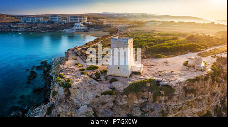 Ghajn Tuffieha, Malta - schönen Sonnenaufgang bei Ghajn Tuffieha Watch Tower mit Golden Bay Beach im Hintergrund Stockfoto