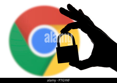 LONDON, Großbritannien - 6. JULI 2018: Google Chrome Sicherheitsprobleme. Silhouette einer Hand mit einem Vorhängeschloss vor der Google Chrome logo Stockfoto