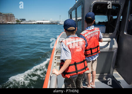 45-Foot Response Boat ist ein United States Coast Guard Response Boat – Medium, das für Such- und Rettungseinsätze und Küstensicherheitsmissionen eingesetzt wird. Das Archivbild zeigt zwei Jugendliche, die am 26. Juni 2018 mit einer Station Boston Crew an Bord des Schiffes fuhren, nachdem sie vom Sektor Boston für die Unterstützung eines in Not geratenen Schwimmers am Walden Pond geehrt wurden. Stockfoto