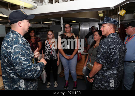 NORFOLK, Virginia (26. Juni 2018) - Aviation Electronics Technician 1. Klasse Charles Fletcher, links, von Jacksonville, Florida, bietet eine Besichtigung der USS Gerald R. Ford's (CVN 78) Aviation intermediate Instandhaltungsabteilung Mitglieder der Naval Air Systeme Befehl in Patuxent River, Maryland bei einem Rundgang durch das Schiff. (Elemente dieses Fotos sind verschwommen aus Gründen der Sicherheit wurde.) (U.S. Marine Foto von Mass Communication Specialist 1. Klasse Jeff Troutman) Stockfoto