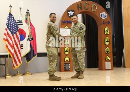 CAMP RED CLOUD, Republik Korea - Ehre Absolvent, Staff Sgt. David K. Arnold, 2 Infanterie Division ROK-U.S. Kombinierte Spaltung noncommissioned Officer, präsentiert eine Bescheinigung der Anerkennung im Namen der Abschlussklasse zu Gastredner, Sgt. Maj. Gabriel Camacho, 2-ID/RUCD Chirurg Sergeant Major für seine Worte der Weisheit während der Anfang Zeremonie bei der Installation theater Juni 28. Der Anfang Zeremonie markiert den Abschluss der ersten 2-ID/RUCD Kampf Personal NCO-Kurs. (U.S. Armee Foto von KATUSA Pvt. Seung Ho Park 2 ID/RUCD Public Affairs) Stockfoto