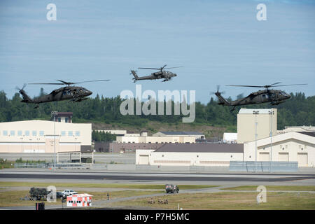 Der Sikorsky UH-60 Black Hawk ist ein zweimotoriger Nutzhubschrauber, der von der United States Army eingesetzt wird, und der Boeing AH-64 Apache ist ein zweimotoriger Angriffshubschrauber, der für die Luftunterstützung und Panzerabwehrmissionen ausgerüstet ist. Am 1. Juli 2018 schwebten zwei UH-60 Hubschrauber und ein AH-64 während einer Joint Forces Demonstration im Arctic Thunder Open House auf der Joint Base Elmendorf-Richardson, Alaska. Das Archivbild dokumentiert die Mover-Anzeige des Drehflügels. Stockfoto