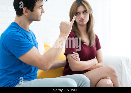 Paar Beziehung Konzepte. Jungen asiatischen Mann, der versucht, mit seiner Freundin zu versöhnen, nachdem ein Argument auf Sofa. Frau empfindlich mit seinem schlechten Wort. Stockfoto