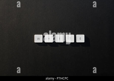 Beschreibung des Wortes Weiß mit Tastatur Buchstaben auf schwarzem Hintergrund Stockfoto