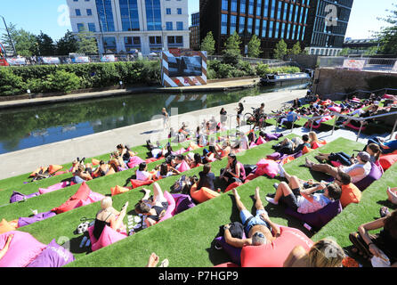 Menschen entspannend auf den Stufen Getreidespeicher Square, Kings Cross, dem Everyman Sommer der Liebe Film Festival zu sehen, im Norden von London, Großbritannien Stockfoto