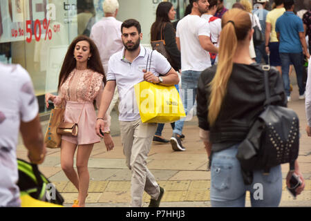 Käufer und Touristen die Einkaufstaschen zu Fuß vorbei am Kaufhaus Selfridges in der Oxford Street in Central London. Stockfoto