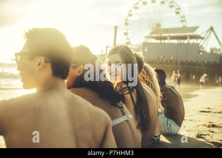 Gruppe von Freunden am Strand sitzen Stockfoto