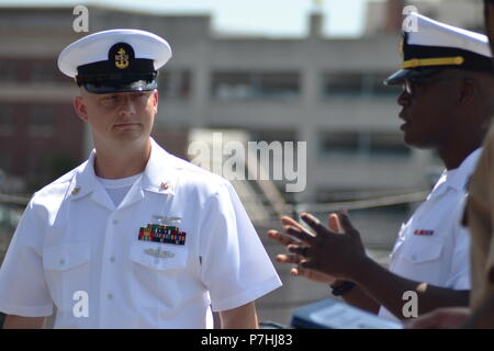 AOC Christopher Crabtree, von der USS Gerald R. Ford, hört zu, einige einleitende Bemerkungen von der Anwerbung Offizier während seiner Dienstzeit re-Zeremonie auf der USS Wisconsin. Die USS Wisconsin (BB-64) ist ein Iowa - Klasse Schlachtschiff, die ursprünglich im Jahr 1944 in Betrieb genommen. Da stillgelegt wird, hat neben dem Hampton Roads Naval Museum und Nauticus liegt in der Innenstadt von Norfolk, Virginia als Museumsschiff. Das Museum ist in der Lage, militärische Zeremonien, wie Re-enlistments, Promotions und Abgänge an Bord der legendären USS Wisconsin kostenlos. Interessierte Befehle und Einzelpersonen Stockfoto