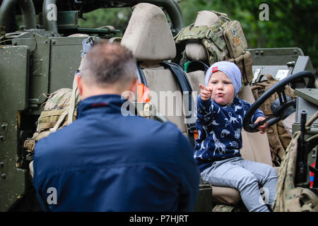 Ein Polnisches Kind Punkte an seinen Vater während des Standorts in einem Mobilität Weapon-Mounted Installation Kit "Schakal" mit der britischen Armee 1. Queen's Dragoon Guards bei einer statischen Anzeige mit Battle Group Polen in Lötzen, Polen am 30. Juni 2018. Battle Group Polen ist ein einzigartiges, multinationale Koalition von USA, Großbritannien, Kroatischen und rumänischen Soldaten, die mit der polnischen 15 mechanisierte Brigade als Abschreckung Kraft zur Unterstützung des NATO-Enhanced vorwärts Präsenz dienen. (U.S. Armee Foto von SPC. Hubert D. Delany III/22 Mobile Public Affairs Abteilung) Stockfoto