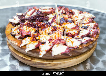 Holzplatte der galizischen Stil gekochten Tintenfisch mit Paprika und Olivenöl. Pulpo a la gallega Stockfoto