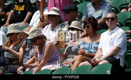 Zuschauer schirmt sich von der Sonne auf Court 2 an Tag 5 der Wimbledon Championships in der All England Lawn Tennis und Croquet Club, Wimbledon. Stockfoto