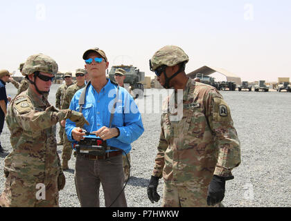 CAMP BUEHRING, Kuwait - Florida reg. Rick Scott (rechts) betreibt einen Kran in das Neuladen der High Mobility Artillery Rocket System (HIMARS) Juli 3, 2018 verwendet. Er reiste nach Kuwait Soldaten mit Bravo Batterie, 3.BATAILLON, 116 Field Artillery Regiment, Florida nationalen Schutz, der im Januar mobilisiert zu erfüllen. Scott Unterstützung ist Spc. Cody Beeson (links) von Lake Wales, Fla und Sgt. Darius Williams, Haines City, Fla (U.S. Armee Foto von Sgt. 1. Klasse Doug Rollen) Stockfoto