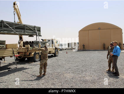 CAMP BUEHRING, Kuwait - Florida reg. Rick Scott (rechts) betreibt einen Kran in das Neuladen der High Mobility Artillery Rocket System (HIMARS) Juli 3, 2018 verwendet. Er reiste nach Kuwait Soldaten mit Bravo Batterie, 3.BATAILLON, 116 Field Artillery Regiment, Florida nationalen Schutz, der im Januar mobilisiert zu erfüllen. Scott Unterstützung ist Spc. Cody Beeson des Lake Wales, Fla. Sgt. Darius Williams, Haines City, Florida ansässig ist, leiten Sie die Last auf dem Anhänger. (U.S. Armee Foto von Sgt. 1. Klasse Doug Rollen) Stockfoto