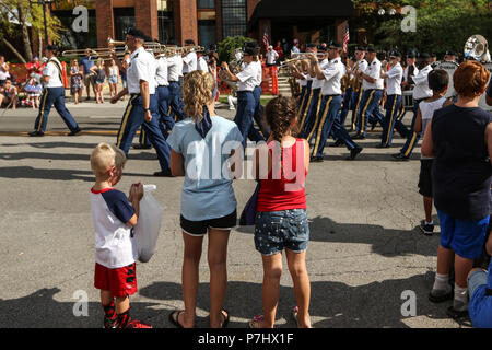 Kinder und Erwachsene zusehen, wie 122 Army Band Märsche des Ohio National Guard von während der Roten, Weißen und BOOM! Parade Juli 3, 2018, in der Innenstadt von Columbus, Ohio. Mehr als 100.000 Zuschauer säumten die 1 Meile parade Route zum Tag der Unabhängigkeit zu feiern und zu sehen, Und danke, Militärdienst Mitglieder und Veteranen. Ohio National Guard Unterstützung für die Parade enthalten auch eine gemeinsame Color Guard und Militärfahrzeugen. (Ohio National Guard Foto von Sgt. Joanna Bradshaw) Stockfoto