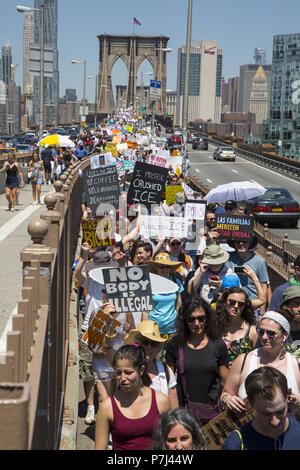 In einem nationalen Tag des Protestes gegen die grausame und ungerechte Behandlung von Familien an der Mexikanischen Grenze zwischen den USA und Tausenden von New Yorkern sammelte und marschierte über die Brooklyn Bridge aus dem sprechen gegen die faschistischen wie Einwanderungspolitik der Trumpf-Verwaltung. Stockfoto