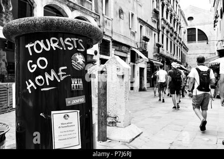 Venedig, Italien, 18. Juni 2018: "Touristen nach Hause gehen' Graffito über litterbin in Venedig