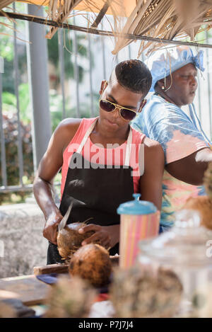 Ein junger Mann arbeitet an einem Kokosmilch-Stand in der Altstadt von Havanna, Kuba. Stockfoto