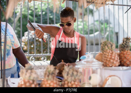 Ein junger Mann arbeitet an einem Kokosmilch-Stand in der Altstadt von Havanna, Kuba. Stockfoto