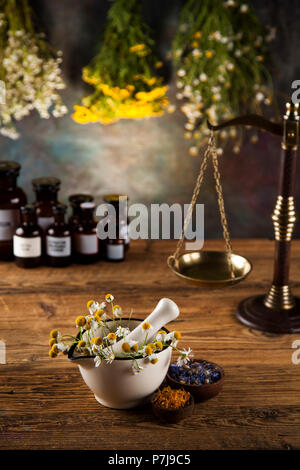 Kräuter, Beeren und Blumen mit Mörtel, Holz Tisch Hintergrund Stockfoto