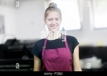 Porträt eines lächelnden Frau, die in einer Fabrik Stockfoto