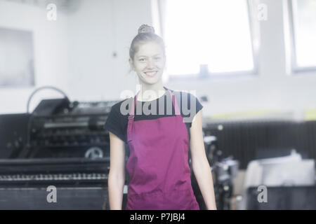 Porträt eines lächelnden Frau, die in einer Fabrik Stockfoto