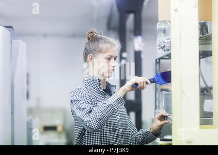Frau mischen Druckfarbe in der Druckmaschine Stockfoto