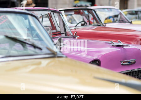 Eine Gruppe von farbigen klassische amerikanische Autos in eine Menge in Havanna, Kuba geparkt. Stockfoto