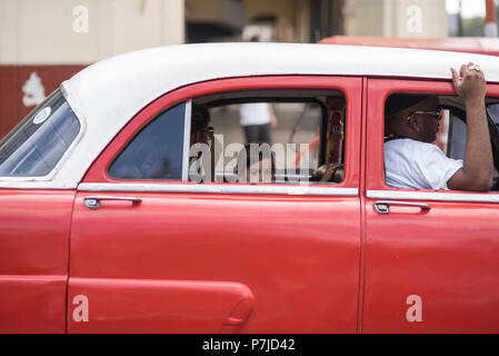 Ein junges Mädchen im Auto nimmt Blickkontakt mit mir auf, als ihre Eltern in Havanna, Kuba, an einer roten Ampel warten. Stockfoto