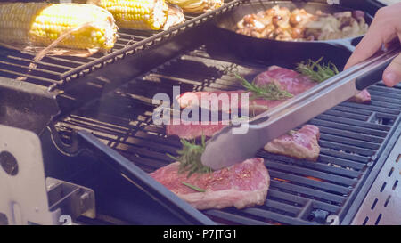 Schritt für Schritt. Grillen New York Strip Steak auf dem Grill im Freien. Stockfoto