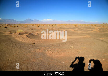 Schatten von zwei Touristen auf dem Boden der Aldea de Tulor alten Dorfes, San Pedro de Atacama im Norden von Chile Stockfoto