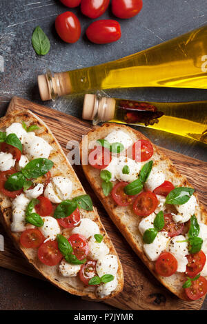 Caprese bruschetta Toasts mit Cocktailtomaten, Mozzarella und Basilikum. Ansicht von oben Stockfoto