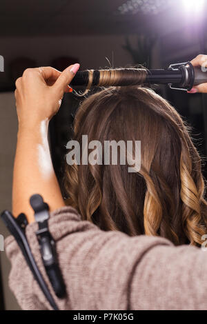 Friseur die Haare kräuseln an einen Client Stockfoto