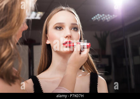 Make-up-Frau Anwendung red Lip Gloss auf ein Modell Stockfoto