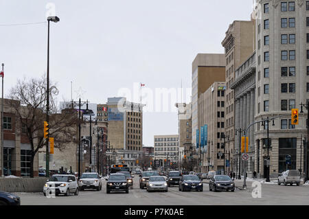 WINNIPEG, KANADA - 2014-11-17: Verkehr auf Portage an der Kreuzung nach Norden Blick auf Main St. Route 85, auch als Portage Avenue genannt, ist eine wichtige Verkehrsachse in der kanadischen Stadt Winnipeg, Manitoba Stockfoto